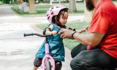 toddler girl on the push bike with father in the park
